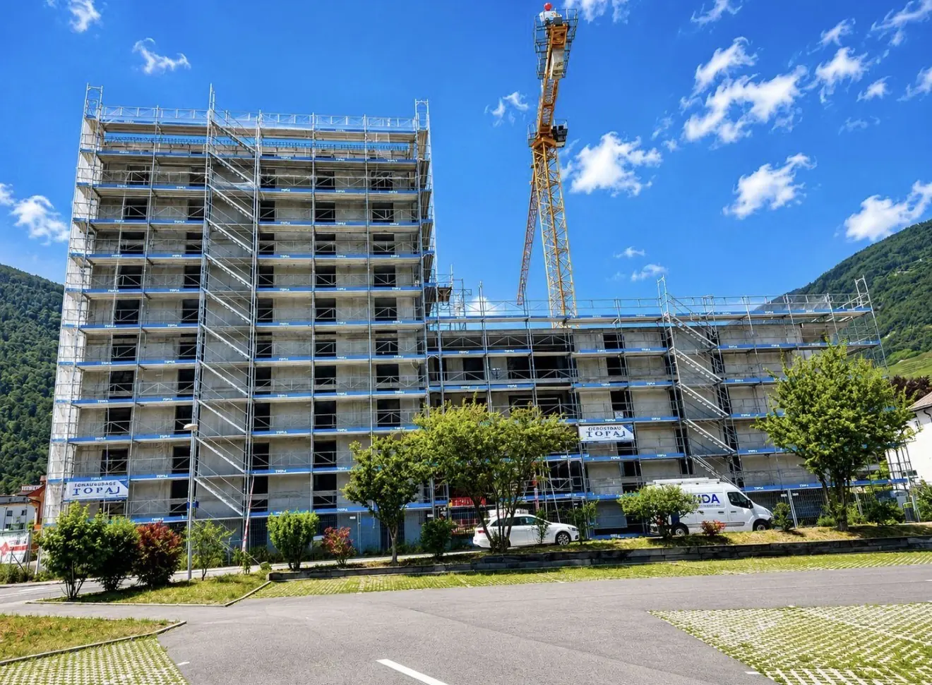 Grand immeuble résidentiel échafaudé par TOFAJ avec grue, Suisse romande